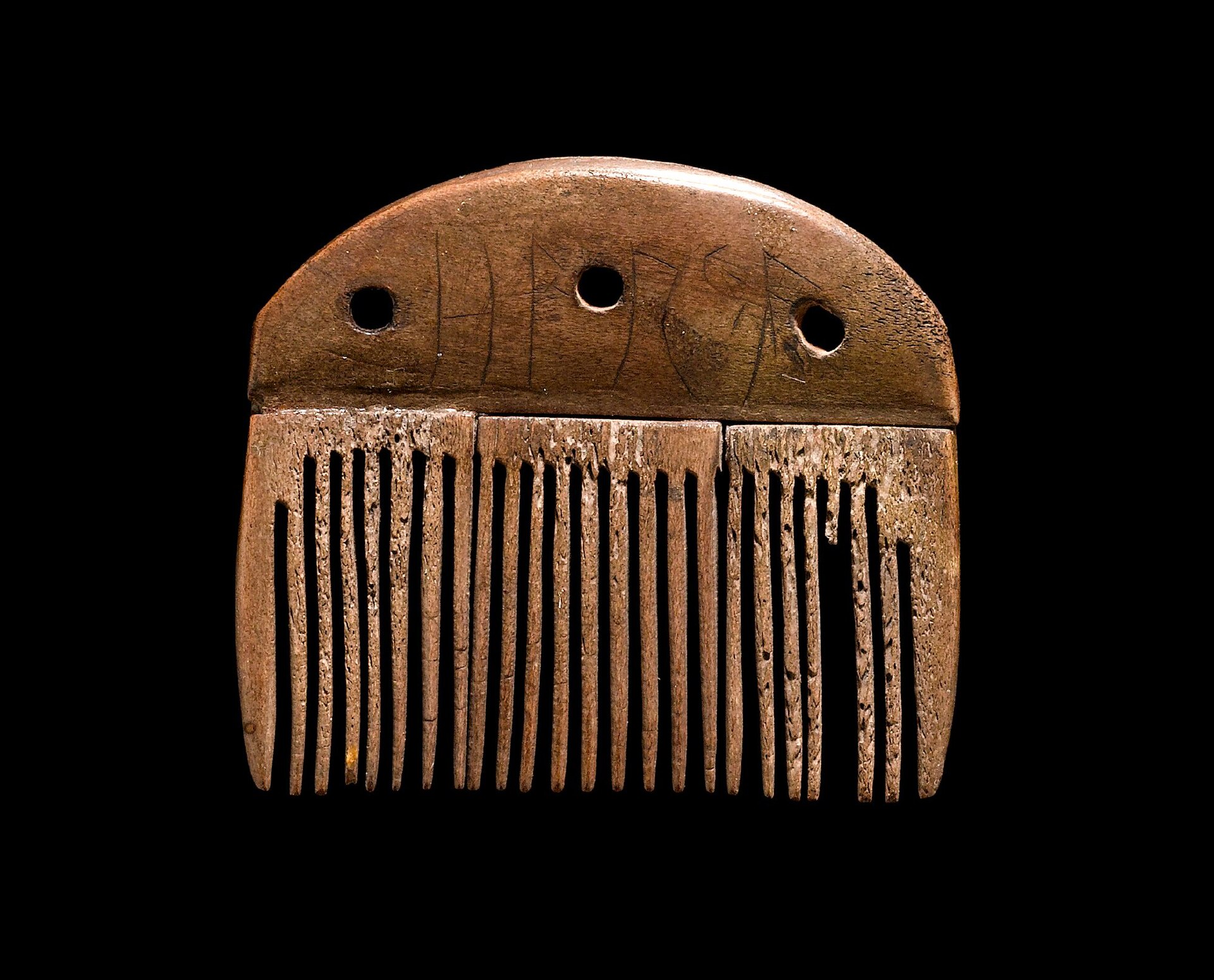 A small comb from Vimose, Denmark, with five runes reading harja scratched across its handle